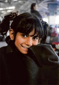 A child tourist feeling amused in traditional Kashmiri dress Pheran in Jammu.