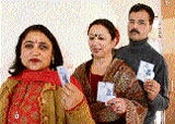 Voters show their voter cards at one of the polling booths in Shimla on Wednesday.