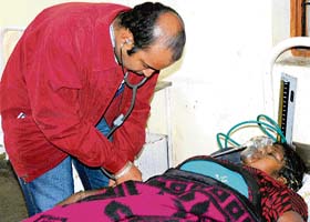 A doctor examines Meena Devi, who suffered from carbon monoxide poisoning, at the trauma centre at the civil hospital in Karnal
