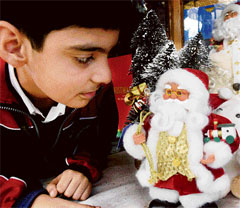Though Christmas is still a week away, yet shops have started attracting customers searching for gifts befitting the occasion. Here a boy looks at various gifts in a shop before making a choice. 