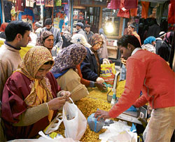 Kashmiri women purchasing bakery items from a vendor in a busy market ahead of Id festival in Srinagar on Wednesay.