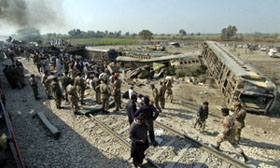 Pakistani soldiers and rescue workers gather beside the wreckage of a passenger train following an accident in the town of Mehrabpur