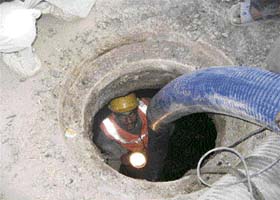 A labourer busy cleaning a sewer