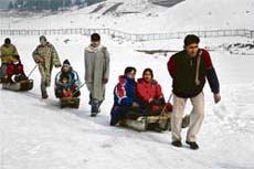 Tourists enjoy a sledge ride on the slopes of the world-famous Gulmarg Health Resort, 55 km north of Srinagar. Snowfall in the state over the past few days has attracted hundreds of domestic and foreign ski tourists to Gulmarg.