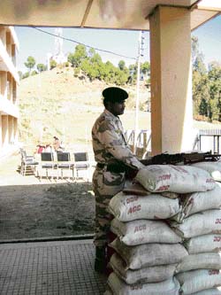 An ITBP jawan stands guard at the entrance to Govt Degree College, Basa, where EVMs of the Chachiot assembly segment have been kept.