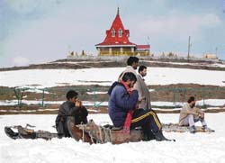Kashmiri sledge drivers wait for tourists at Gulmarg, a world famous health ski resort. Snowfall over the past few days has attracted hundreds of domestic and foreign ski resorts to Gulmarg.