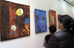 A woman watches an exhibition, AAR-PAAR, at AIFACS Art Gallery in the Capital on Tuesday.