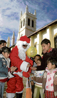 Santa Claus entertains children near the Shimla Church on Tuesday.