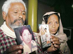 Budhai Ram and his wife show pictures of their missing sons in Amritsar on Tuesday.