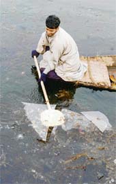 A boatman uses his paddle to break the ice on Dal Lake in Srinagar