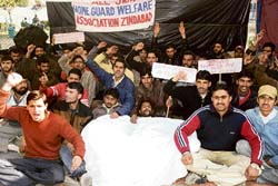 Home guards stage a dharna in front of the divisional commissioners office in Jammu on Thursday.