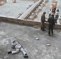 Sanjeev Baweja, computer operator in State Transport Corporation, lies in a pool of blood after he fell from the top floor of Jawahar Vyapar Bhawan at Janpath in the Capital on Friday.