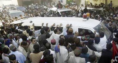 Supporters of Benazir Bhutto crowd around an ambulance carrying her body during her funeral procession in Garhi Khuda Baksh on Friday.