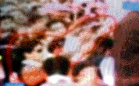 This TV grab taken from Pakistani television broadcast Dawn News on Saturday shows an unidentified assailant reportedly pointing a gun towards Benazir Bhutto (unseen) during a rally at which she was assassinated.