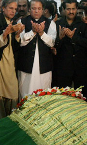 Former Pakistani Prime Minister Nawaz Sharif (C) prays along with his party leaders at the grave of slain Pakistani leader Benazir Bhutto at the Bhutto familys mausoleum in Ghari Khuda Baksh, on Saturday. Sharif met Bhuttos husband at the family home in southern Pakistan to offer his condolences.