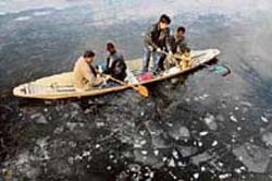 Boatmen row through a partially frozen Dal Lake in Srinagar on Sunday. The temperature of the town dipped to -7.2C.