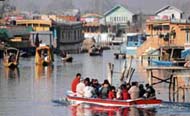 Tourists enjoy motor boat ride in Srinagars Dal Lake as major portion of the lake is still frozen. 