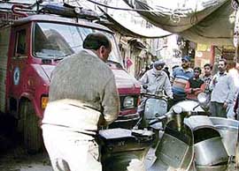 A fire officer removes a scooter blocking the way of a fire tender while on its way to douse a fire in Mali Ganj, Ludhiana, on Monday.