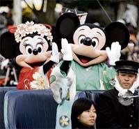 Disney characters Mickey (centre) and Minnie Mouse (L), dressed in Japanese traditional kimonos, wave to greet guests from a chauffer driven limousine during a New Year's Day parade at Tokyo Disneyland in Urayasu, Tokyo suburban, on Tuesday to celebrate the "Year of the Rat".
