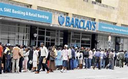 Zimbabweans queue outside a bank due to the ongoing cash crisis in Harare on Monday. Zimbabwe's central bank chief indefinitely extended a Monday deadline to exchange $200,000 bills just hours before they were to cease being legal tender after scenes of chaos at banks across the country
