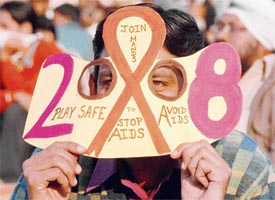 A spectator holds a cutout on aids awareness at a PHL match at Sector 42 hockey stadium in Chandigarh on Tuesday.