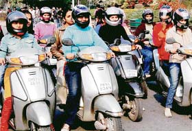 Girls from various local colleges participate in a scooter rally to promote helmets among woman riders as a part of the 19th Road Safety Week in Chandigarh