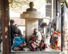 Beggars huddle near Mahatma Gandhis bust where one of them lay dead in Ludhiana.