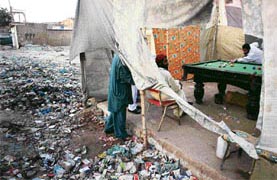 POOL IN CESSPOOL: Pakistan men play pool in a slum of Karachi on Thursday. President Musharraf went on air again to reassert that Benazir Bhutto had ignored his repeated warnings about security matters.