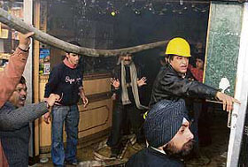 Shopkeepers and firemen try to douse the fire that broke out in a shop in the meat market in Shimla on Friday. 