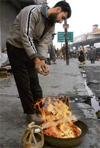 A Kashmiri shopkeeper warms himself around a bonfire in Srinagar on Friday.