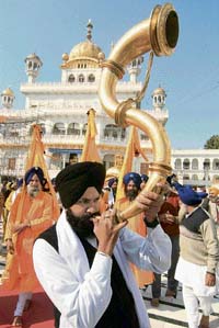 A devotee plays narsingha in a procession at the Golden Temple in Amritsar on the eve of the birth anniversary of Guru Gobind Singh. 
