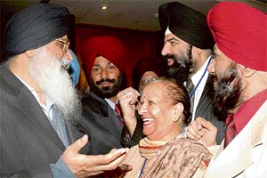 Punjab Chief Minister Parkash Singh Badal shares a light moment with NRIs at a conference in Chandigarh on Saturday.