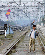 A boy flies a kite on the rail track in Ludhiana