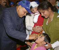 Chief Minister Prem Kumar Dhumal administers polio drops to a child at Hamirpur on Sunday.