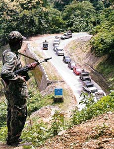 A paramilitary soldier watches over traffic on the Assam-Agartala national highway 44, on the Atharamura Hills, some 65 km east of Agartala