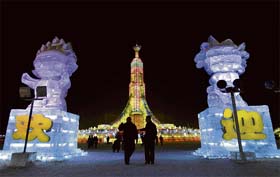 Tourists walk past the 2008 Beijing Olympic mascots made of ice bearing words Welcome during the 24th ice and snow festival in Harbin, northeastern Chinas Heilongjiang province