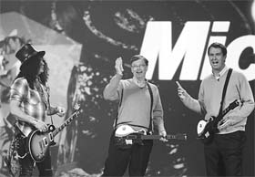 Microsoft Chairman Bill Gates (centre) holds up US$ 20 that he won from Robbie Bach (right), President of the company's Entertainment and Devices Division, as guitarist Slash (left) joins them in a "Guitar Hero" match during the keynote address at the 2008 Consumer Electronics Show (CES) in Las Vegas