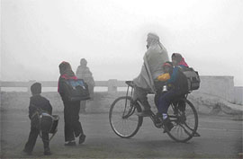 Children on the way to school on a foggy morning in Karnal on Monday. 