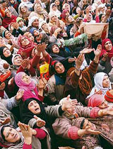 Kashmiri women pray as the prayer leader (unseen) displays the holy relic, believed to be the hair from the beard of Prophet Mohammed, at Dargah Hazratbal in Srinagar on Monday.