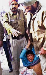 Police officials struggle to detain a juvenile snatcher at Pohir village near Ahmedgarh on Monday.