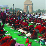 Schoolchildren participate in a painting compitition, as part of the ongoing Road Safety Week, at the India gate lawns in the Capital on Tuesday.
