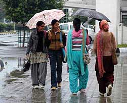 Girls enjoy the rain at Punjabi University in Patiala on Wednesday.