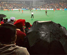 Hockey fans take shelter under umbrellas to view the second final between the Chandigarh Dynamos and the Bangalore Hi-Fliers at the Sector 42 stadium in Chandigarh on Wednesday.