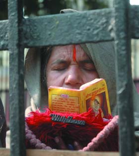  An old woman reads the Bhaghvadgeeta on a pavement in the Capital on Wednesday.