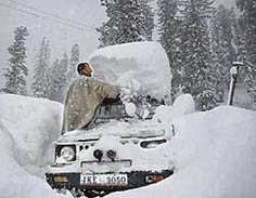 A Kashmiri Muslim cleans his vehicle after heavy snowfall at Gulmarg, about 55 km from Srinagar, on Wednesday. 