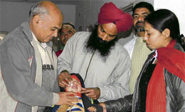 HIV + Mehar Singh administers polio drops toa child at civil hospital, Jagraon.