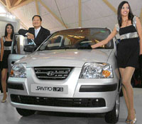 H.S. Lheem, managing director, Hyundai Motor India, poses with Hyundai Santro LPG at its launch in New Delhi on Thursday.