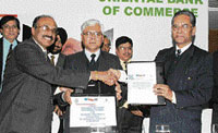 B.K. Sarkar of Oriental Insurance hands over a policy to S.K. Sharma of Oriental Bank of Commerce.