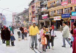 Tourists enjoy skiing on the snow-covered Mall road in Manalis no-traffic zone in the heart of the hill station