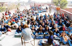 In the absence of adequate number of classrooms, students of Government High School, Noorwala village in Panipat, are forced to sit on the roof of the school building. 
